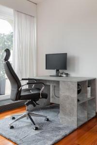 a desk with a computer monitor and a chair at Perle rare nations in Geneva