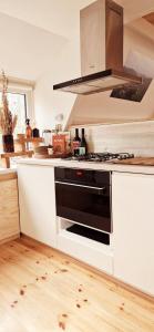 a kitchen with a black stove top oven at A Wood Lodge - zwembad - relax - natuur in Durbuy +31 photos