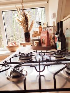 a stove top with a bottle of wine and a window at A Wood Lodge - zwembad - relax - natuur in Durbuy +31 photos