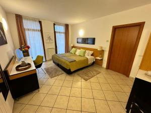 ソンマ・ロンバルドにあるResidence Malpensaのベッドとデスクが備わるホテルルームです。