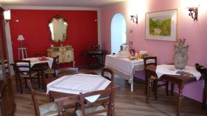 a dining room with tables and chairs and a mirror at Romantico B&B in Serra SantʼAbbondio