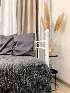 a bedroom with a bed with a gray blanket and a curtain at Cozy Residence Sv. Duh in Zagreb