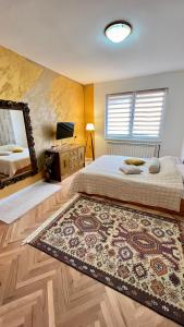 a bedroom with a bed and a mirror and a rug at Guest House Bosnian House in Sarajevo