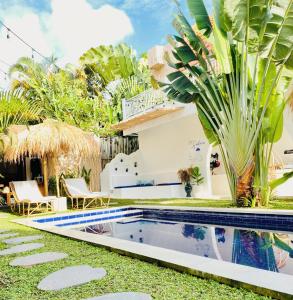 a villa with a swimming pool in the yard at Shortcut Breeze Guest House in Canggu