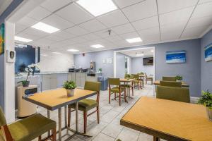 a waiting area with tables and chairs in a room at La Quinta by Wyndham Tampa Brandon West in Tampa