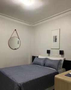 a bedroom with a bed and a mirror on the wall at Lory Studio Hotel in São Paulo