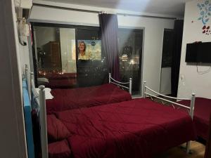 una camera da letto con due letti con lenzuola rosse e una finestra di Al Waha Hostel a Il Cairo