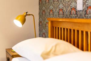 a lamp sitting on a table next to a bed at Captains Lookout (Studio apartment) in Brecon