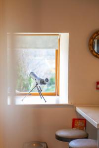 a window with a telescope next to a stool at Captains Lookout (Studio apartment) in Brecon