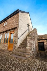 a brick building with stairs leading up to a door at Captains Lookout (Studio apartment) in Brecon