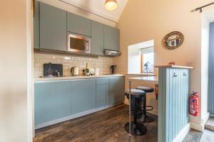 a kitchen with blue cabinets and a counter at Captains Lookout (Studio apartment) in Brecon