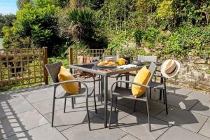 a table with yellow pillows and chairs on a patio at Luxury Town House 8 - Apple Pie Luxury Escapes in Tavistock
