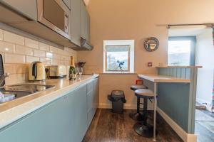 a kitchen with blue cabinets and a counter top at Captains Lookout (Studio apartment) in Brecon