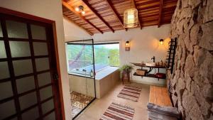 bagno con vasca e porta a vetri di Cabana Rinoceronte a São Bento do Sapucaí Altre 34 foto