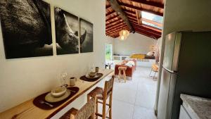 una cucina e una sala da pranzo con tavolo e frigorifero di Cabana Rinoceronte a São Bento do Sapucaí