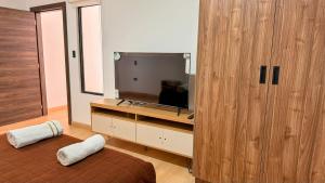 a bedroom with a television and a large wooden cabinet at Edificio Tofino in Quito