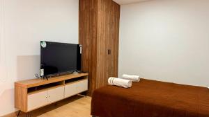 a bedroom with a bed and a flat screen tv at Edificio Tofino in Quito