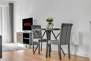 uma mesa com 2 cadeiras e uma secretária com um computador em Colindale NW9 1BED TV/WIFI em Colindale