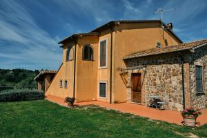 a large yellow building with a grass yard at 8380 Agriturismo il Saragiolo in Manciano