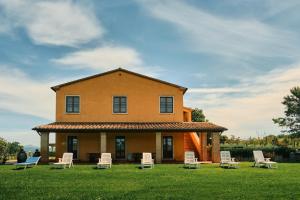 a house with chairs on the lawn at 8380 Agriturismo il Saragiolo in Manciano
