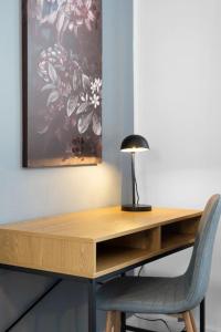 a wooden desk with a lamp and a chair at JOOYFUL STAYS Townhouse in Kevelaer