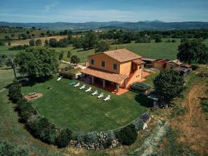 an aerial view of a house with chairs on a field at 8380 Agriturismo il Saragiolo in Manciano