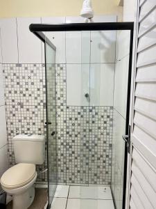 uma casa de banho com um WC e uma cabina de duche em vidro. em Loft Familiar BR-Aeroporto 4 em Uberlândia