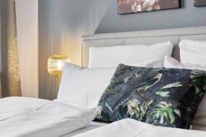 a bed with white sheets and a pillow on it at JOOYFUL STAYS Townhouse in Kevelaer