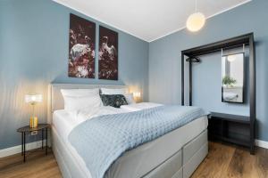 a bedroom with a large bed with blue walls at JOOYFUL STAYS Townhouse in Kevelaer