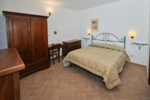 1 dormitorio con cama, mesa y escritorio en 8380 Agriturismo il Saragiolo, en Manciano