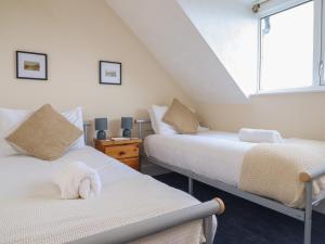 2 camas en una habitación con ventana en Tawelfan, en Llwyngwril