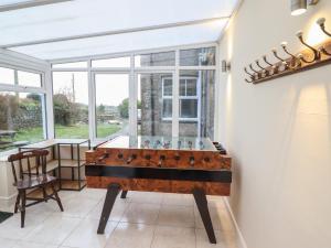 una mesa de ping pong en una habitación con ventana en Tawelfan, en Llwyngwril