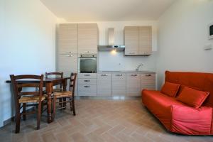 a living room with a couch and a table and a kitchen at 8380 Agriturismo il Saragiolo in Manciano