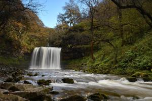 a waterfall in the middle of a river at Captains Lookout (Studio apartment) in Brecon