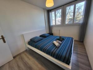 Un dormitorio con una cama con un osito de peluche. en 3 Chambres, accès Rocade, Métro et Tram 7 minutes, en Vénissieux