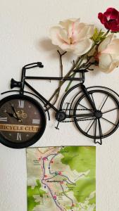 Una bicicleta con flores y un reloj junto a un mapa en Haus Sonnenschein, en Mespelbrunn