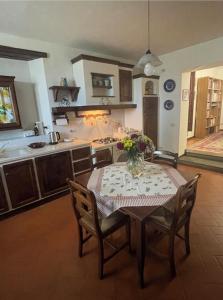 une cuisine avec une table et un vase de fleurs. dans l'établissement Betania, à Pieve di Panzano