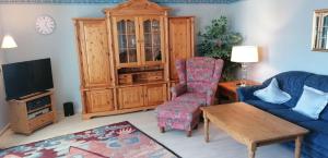 ヴェスターラントにあるSylter-Residenzのリビングルーム(ソファ、椅子、テレビ付)