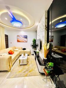 レッキにあるNewly built Smart 4 bed rooms duplex in Ilasan ikate lekkiの青い天井のリビングルーム(ソファ付)