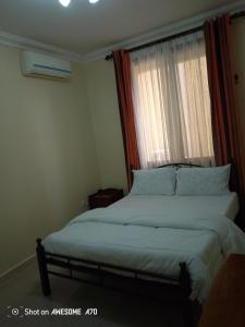 a bedroom with a large bed with a window at Cozy 3BR w/pool & gym in Dar es Salaam