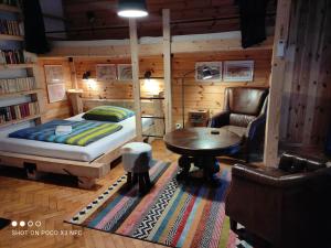 1 dormitorio con cama, mesa y sofá en Cottage Scandi, en Palcmanska Maša