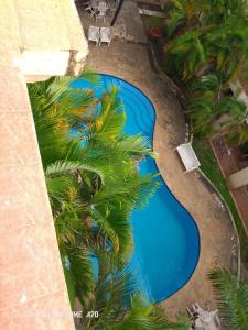 an overhead view of a swimming pool with palm trees at Cozy 3BR w/pool & gym in Dar es Salaam