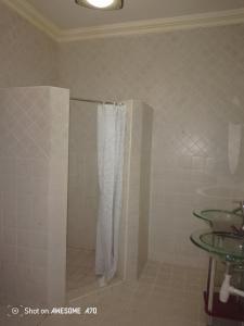 a shower with a white shower curtain in a bathroom at Cozy 3BR w/pool & gym in Dar es Salaam