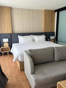 ein Schlafzimmer mit einem großen Bett und einem Sofa in der Unterkunft Sea Beach apartment in Nai Thon Beach
