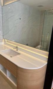 ein Badezimmer mit einem Waschbecken und einem großen Spiegel in der Unterkunft Sea Beach apartment in Nai Thon Beach