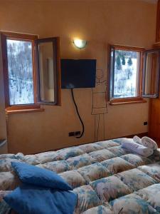 1 dormitorio con 1 cama y TV en la pared en Casa Barbara en Limone Piemonte