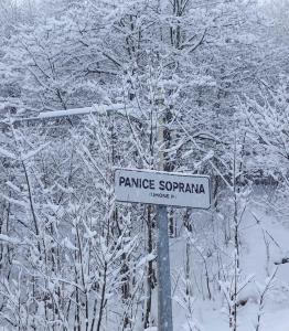 un letrero de la calle en un poste en la nieve en Casa Barbara en Limone Piemonte
