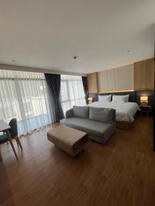 ein Schlafzimmer mit einem Bett und einem Sofa sowie einem Bett und einem Bett in der Unterkunft Sea Beach apartment in Nai Thon Beach