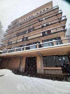 un gran edificio en la nieve con nieve cayendo en Casa Barbara en Limone Piemonte