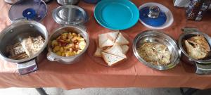 a table topped with different types of food in containers at KANUNKA HOUSE in Sekenani